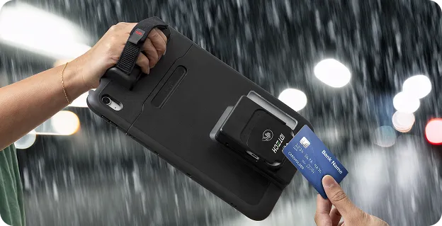 Rugged ID TECH terminal in use outdoors in heavy rain